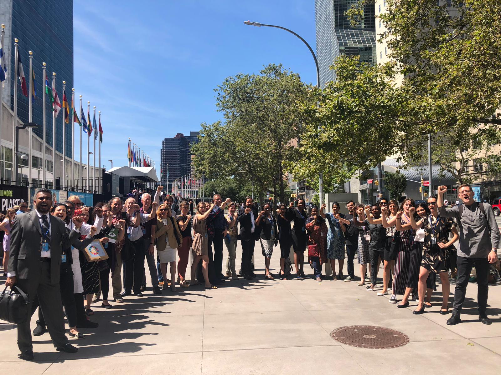 Group picture of approximately 30 people holding their fists up