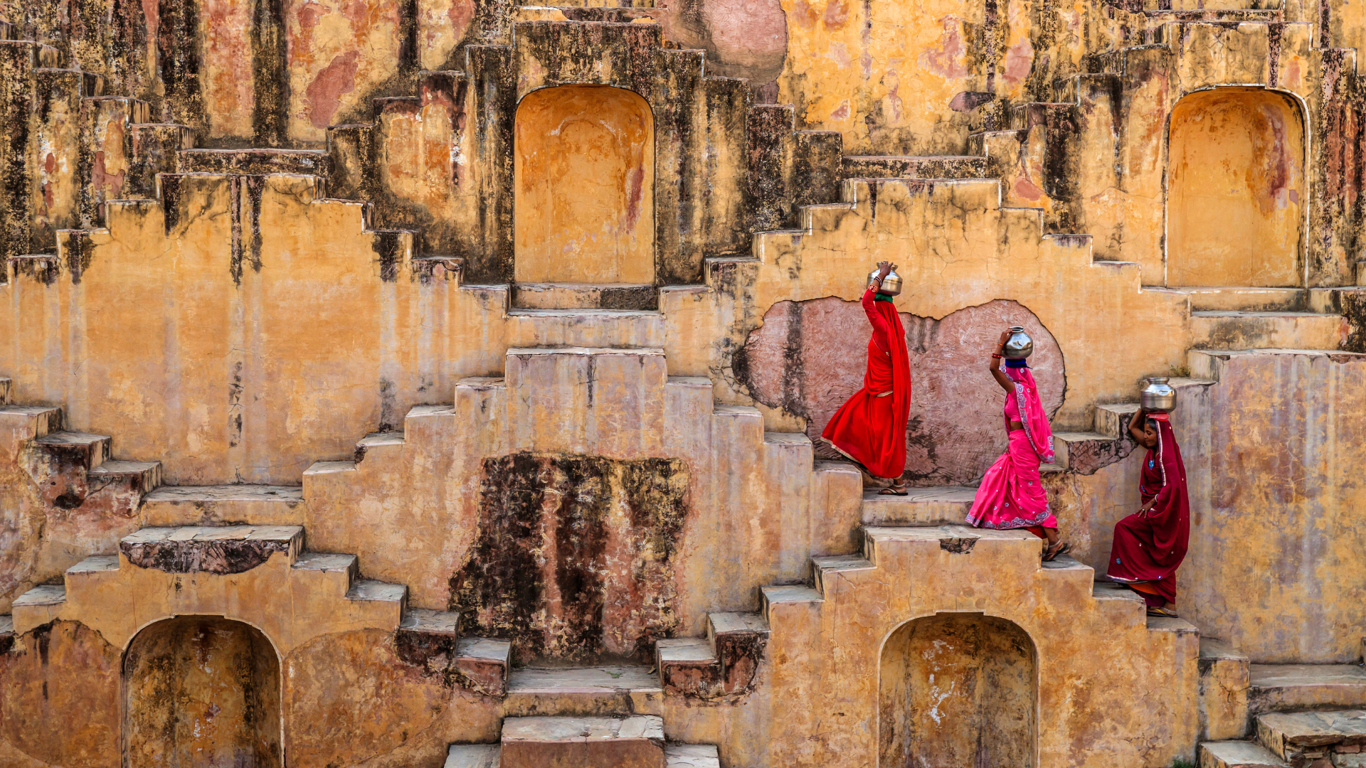3 femmes indiennes transportant de l'eau sur leur tête dans un puit à degrés, près de Jaipur.