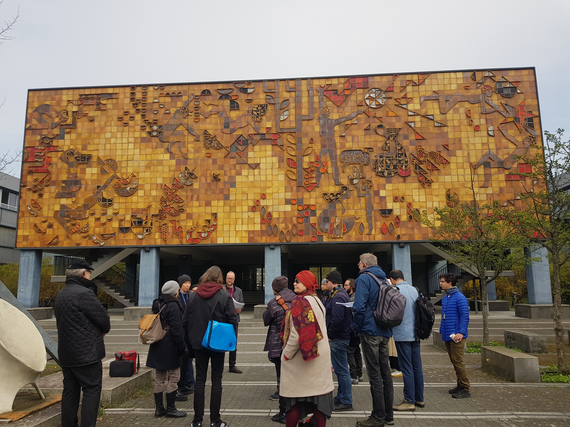 Group of people standing in front of a yellow building