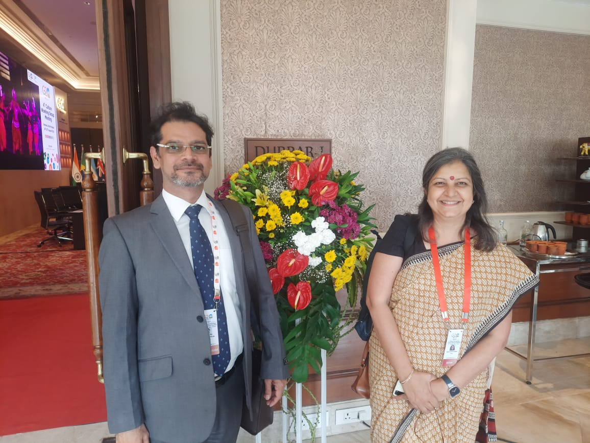 2 people standing in front of a flower bouquet and smiling at the camera