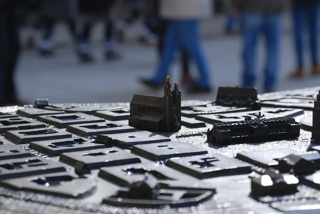 Picture of a zoomed in stone model of the city of Krakow against a blurry background of a street 
