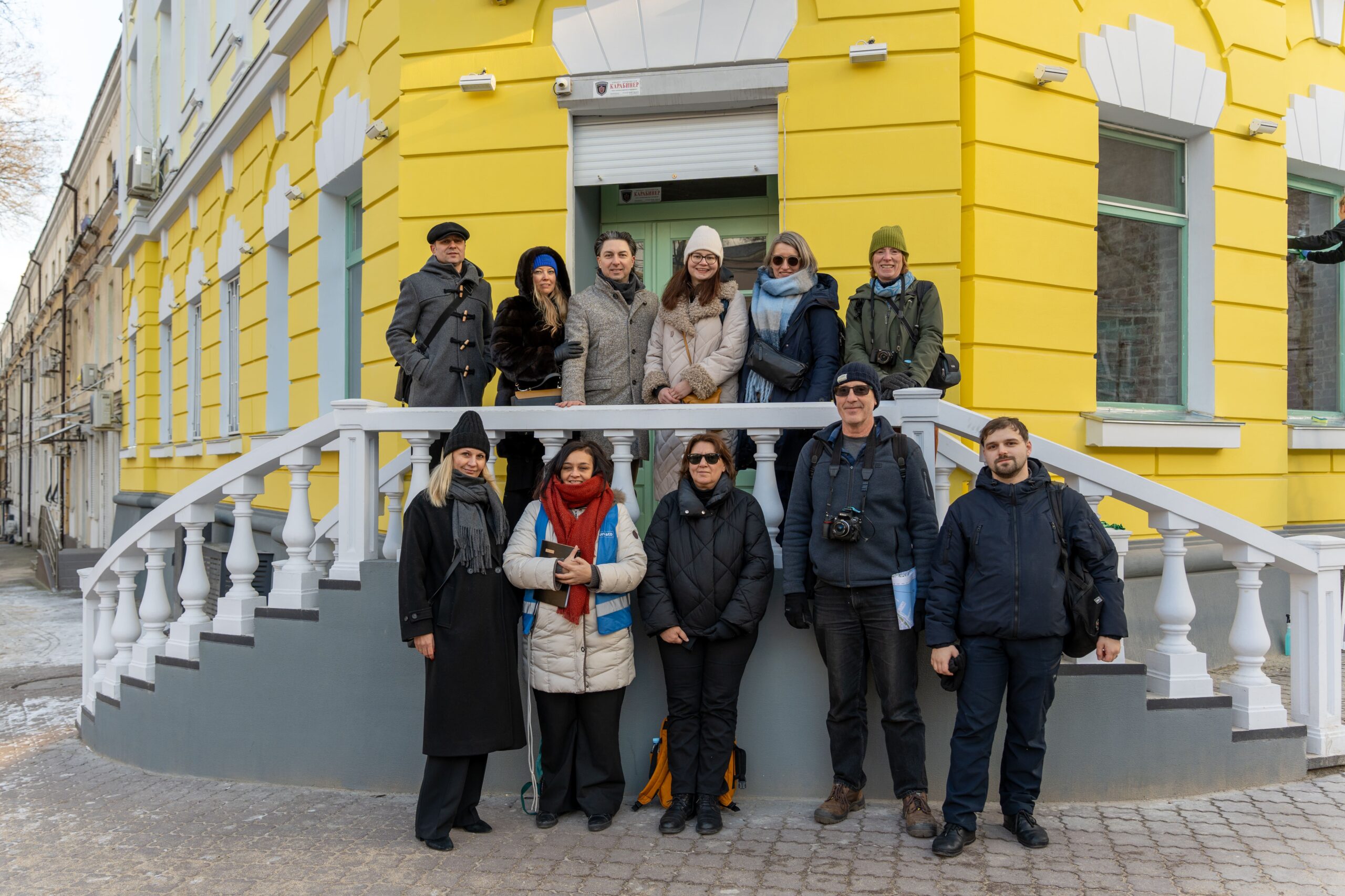 Group of heritage professionals posing in front of a yellow building in Odesa, Ukraine.